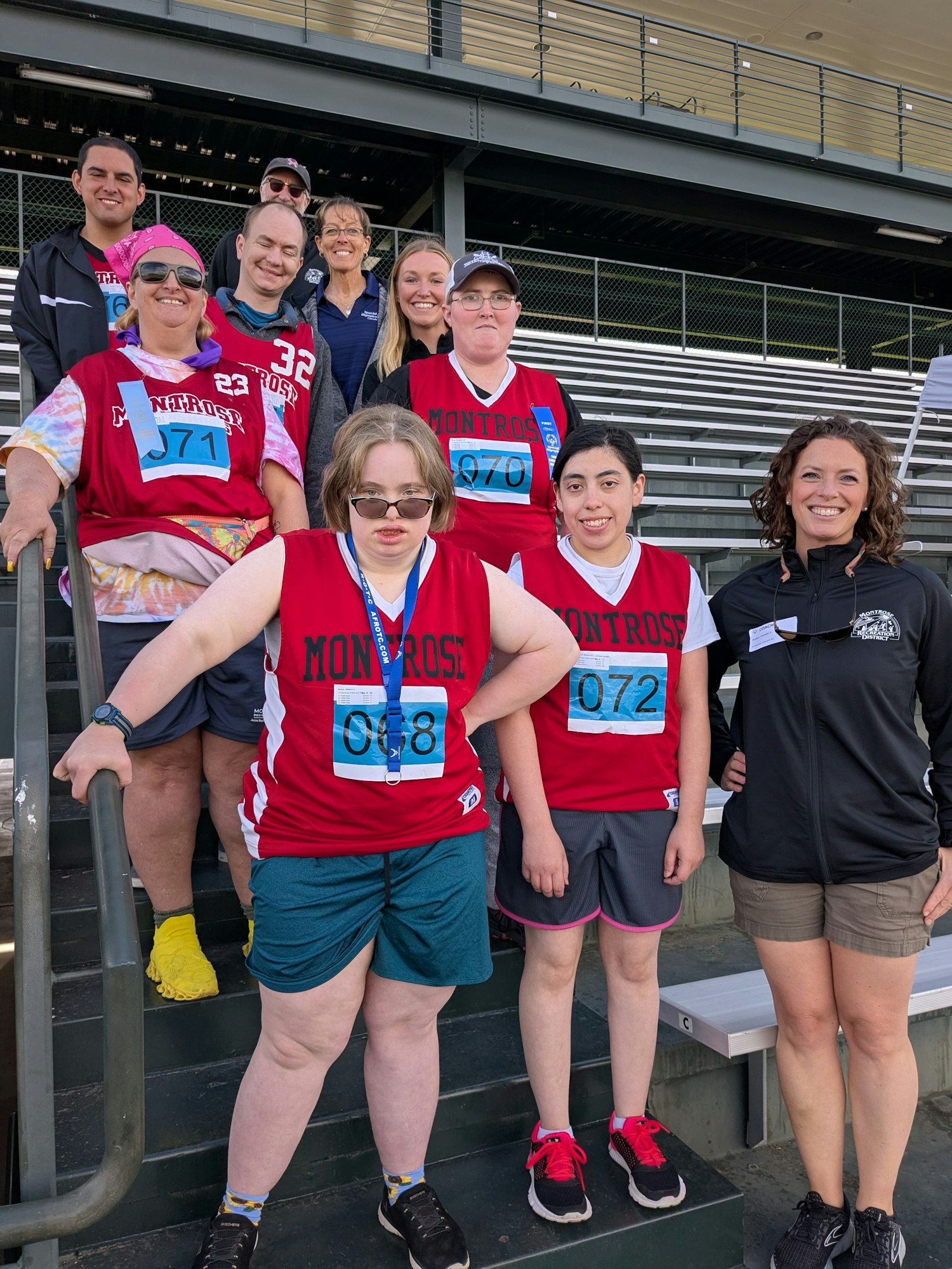 A group of athletes in red jerseys poses together, likely before a sporting event, showcasing teamwork and community spirit.