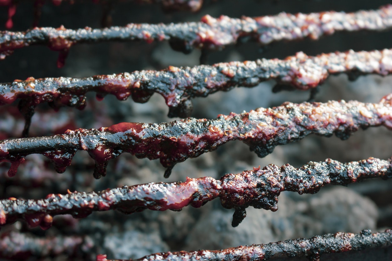 Grill grates with residual charred food and grease.