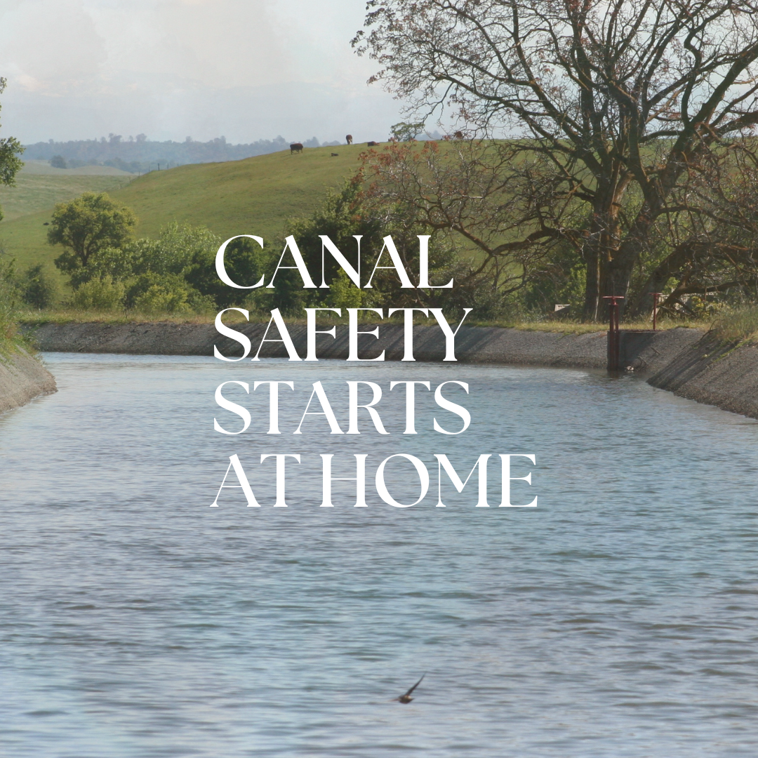 A canal with trees and a hill in the background. Text reads "Canal Safety Starts at Home."