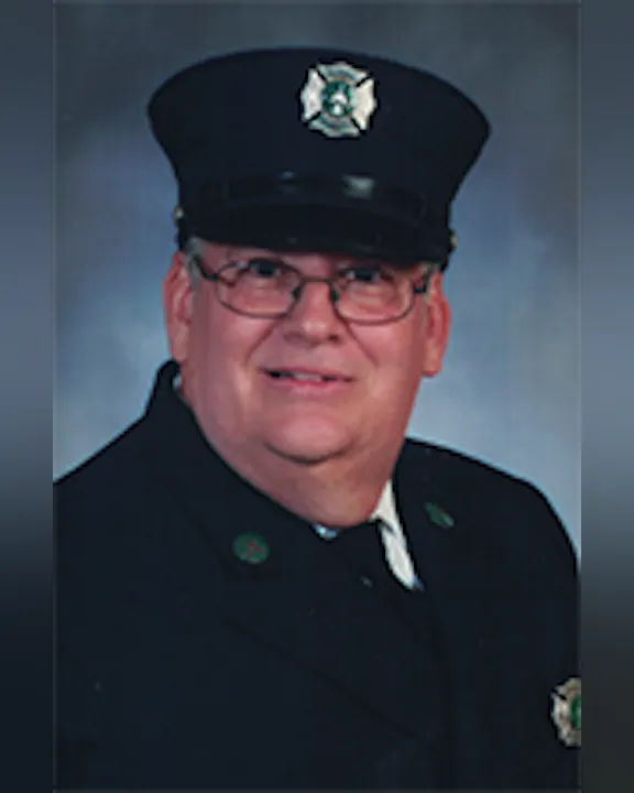 Walter McGarrity wearing a dark uniform and a hat with a badge.