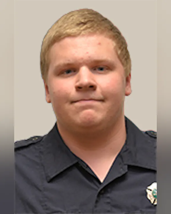 Tim Hess in a dark uniform with a badge.