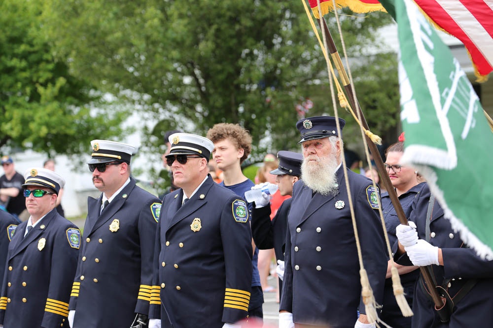 Firefighters of the Minoa Fire Department in uniform listen at attention to Mayor Brazill's remarks on the significance of Memorial Day.