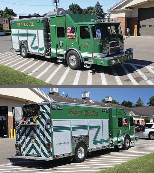 Green fire rescue vehicle with emergency equipment, parked outside a fire station.