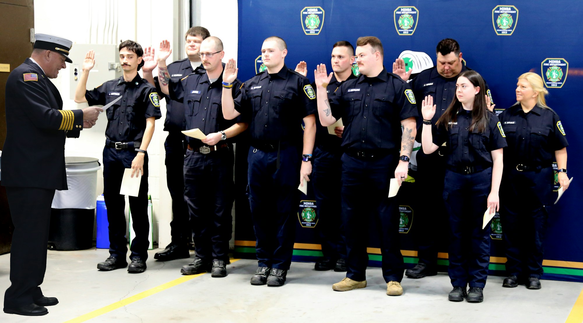A group of new recruits is being sworn in by a commanding officer in a formal ceremony.