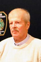 Dave Matthes, Sr. dressed in a light-colored sweater against a dark blue backdrop