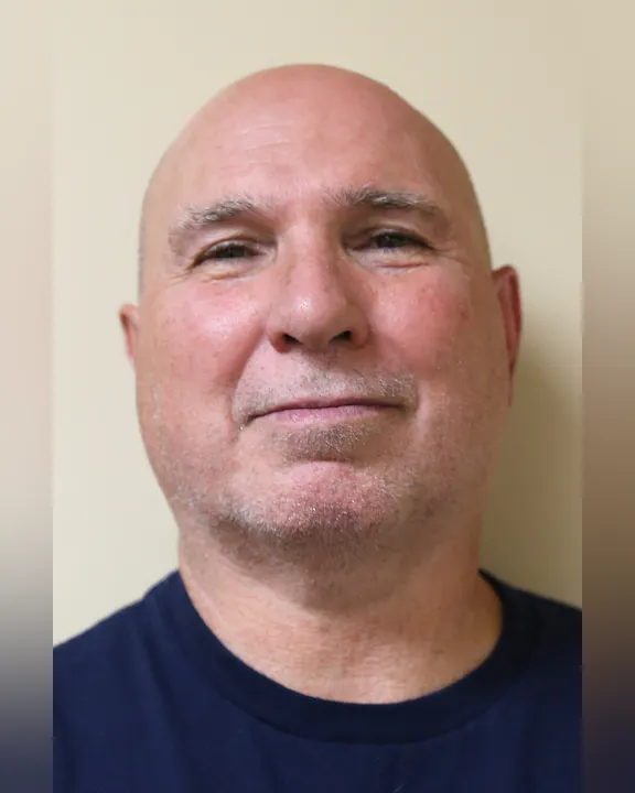 Rich Sabin, smiling, against a plain background.