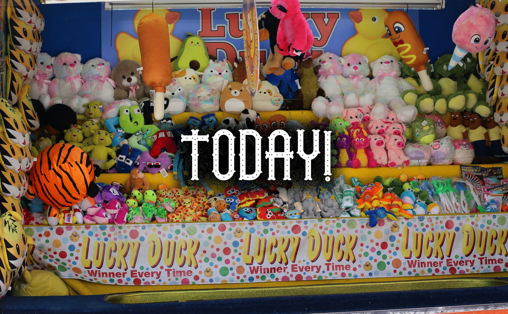 An array of colorful plush toys at a "Lucky Duck" carnival game with the word "TODAY!" superimposed on top.