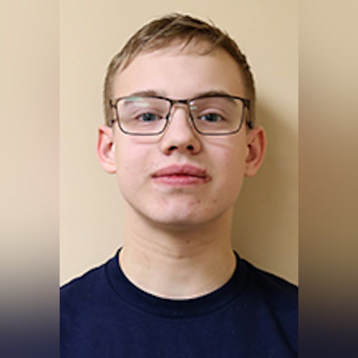 Connor Young wearing glasses and a dark shirt against a plain background.