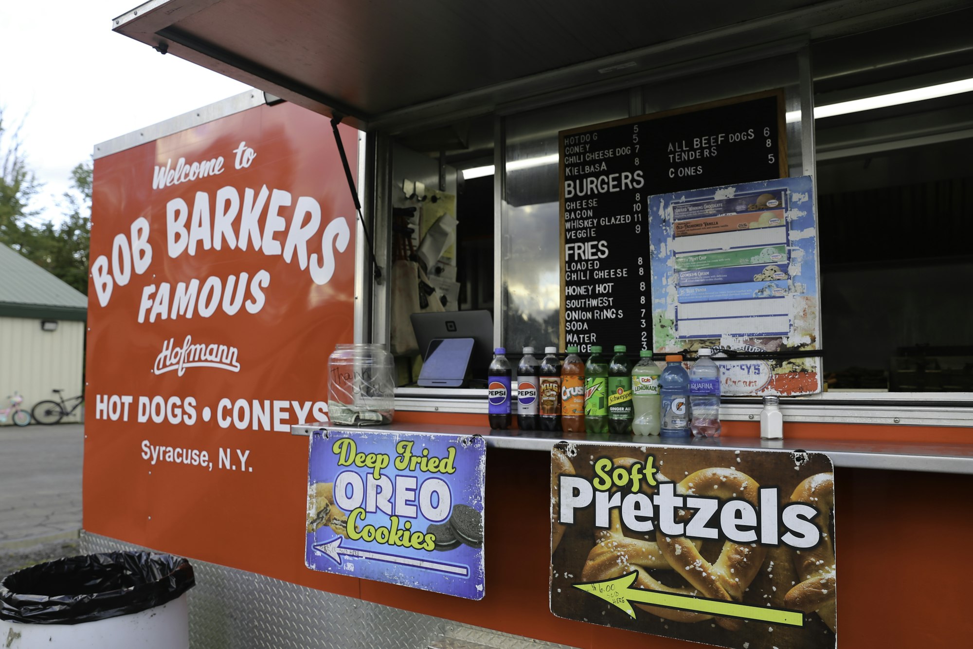 A food stand selling hot dogs, burgers, fries, and snacks like deep-fried Oreos and soft pretzels.