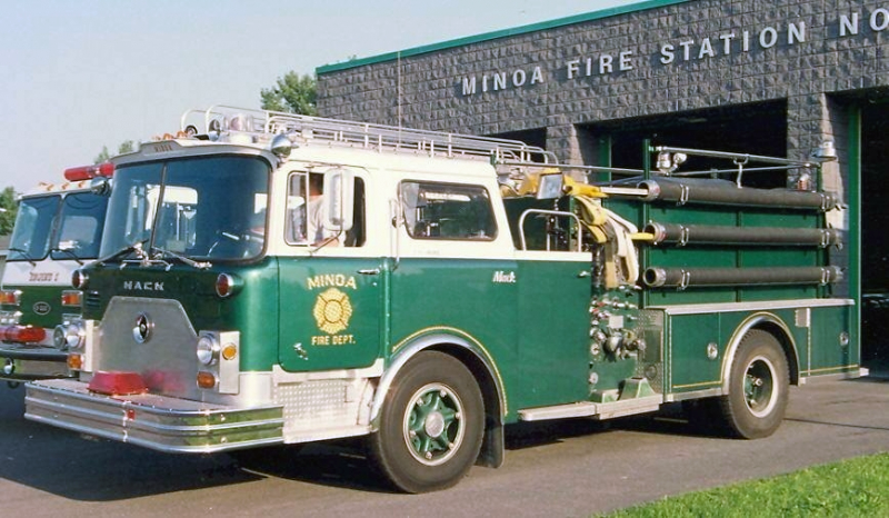A vintage green and white fire truck parked outside the Minoa Fire Station No. 1.