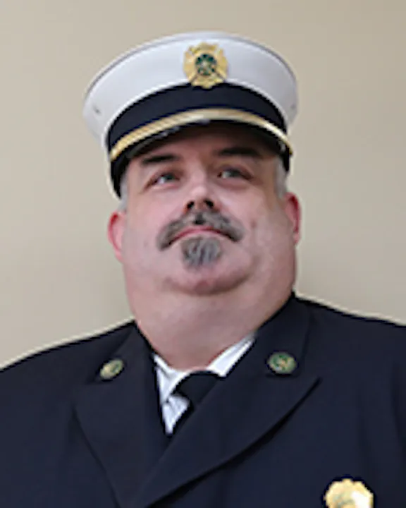 Jeremy erard in a firefighter's dress uniform with a cap.