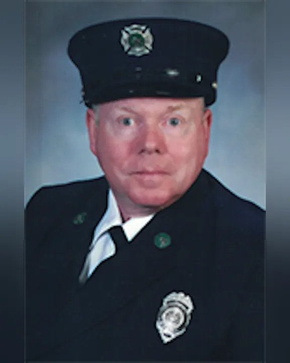 Nick Erard, Jr. in a formal uniform with a cap and badges.