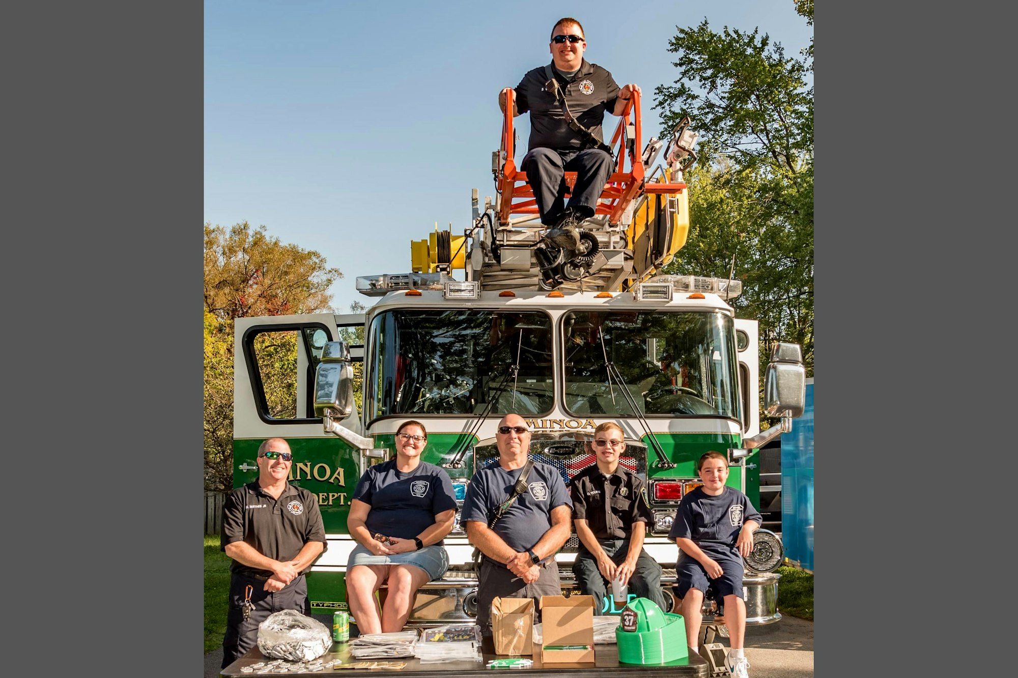 A group of Minoa Fire Department personnel posing in front of a fire engine.