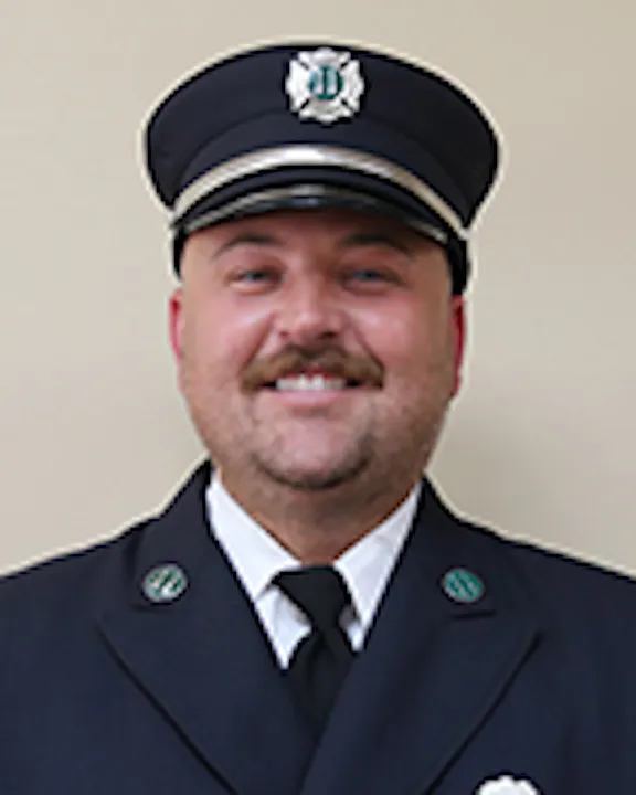Anthony AAlessandrello in a formal uniform with a cap and badge.