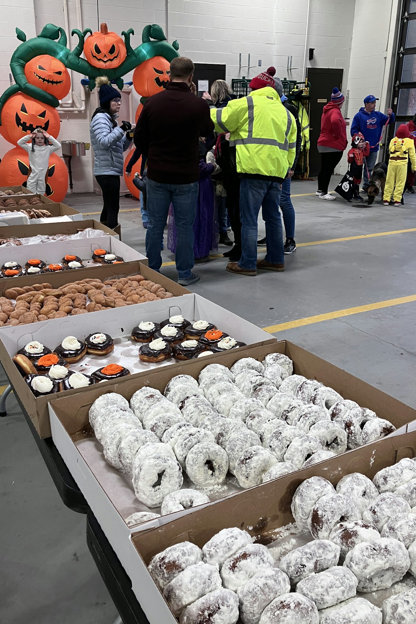 The 2023 Halloween event at the Minoa Fire Station with costumed people, festive doughnuts, and inflatable pumpkins.