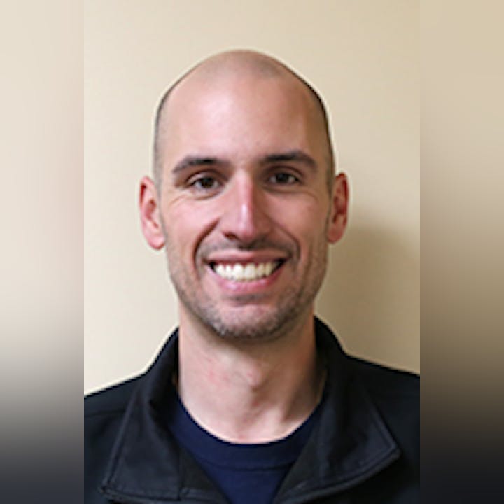 Portrait of Mike DiMauro, against a neutral background.