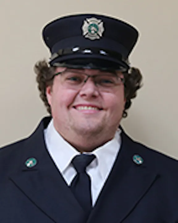 Hunter Matthes in a firefighter's uniform smiling.
