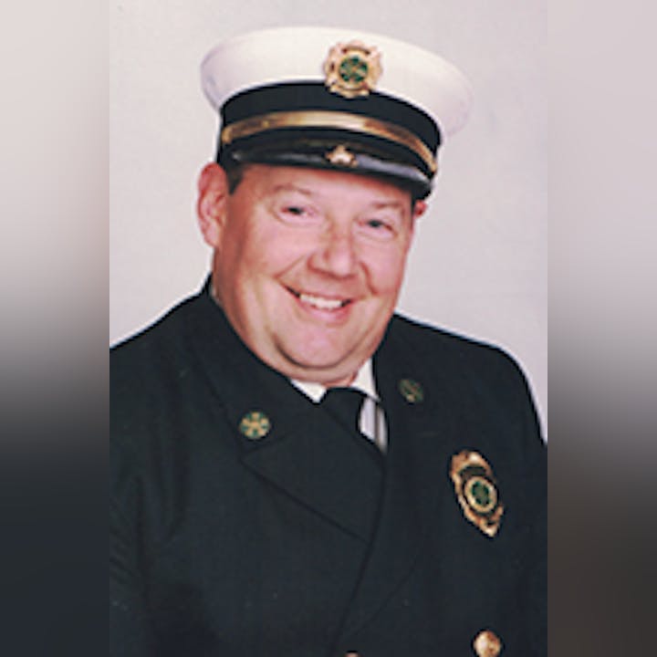 Al Tompkins in a formal uniform with a hat and badge, smiling.
