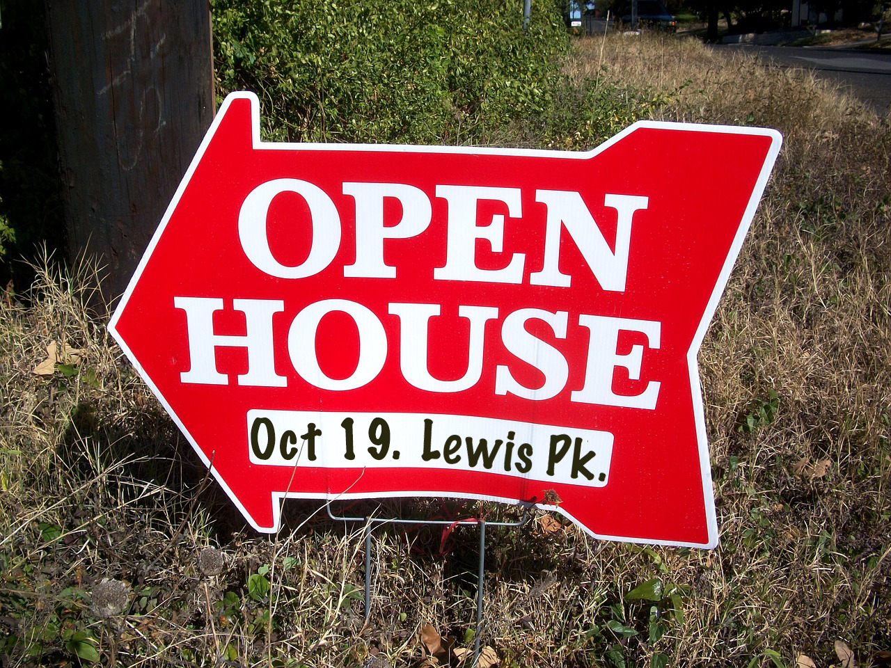 Red "Open House" sign with an arrow, date "Oct 19," and location "Lewis Pk." on grassy ground.