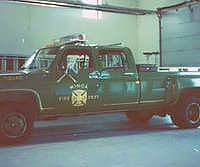 Vintage fire department truck with equipment inside a garage.