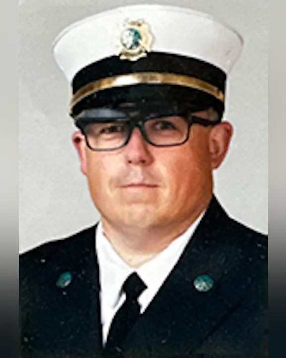 Tim Visser in uniform with a peaked cap, in a formal portrait.