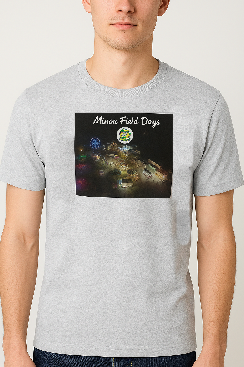 A man modeling a t-shirt. The t-shirt has an aerial nighttime view of Field days.