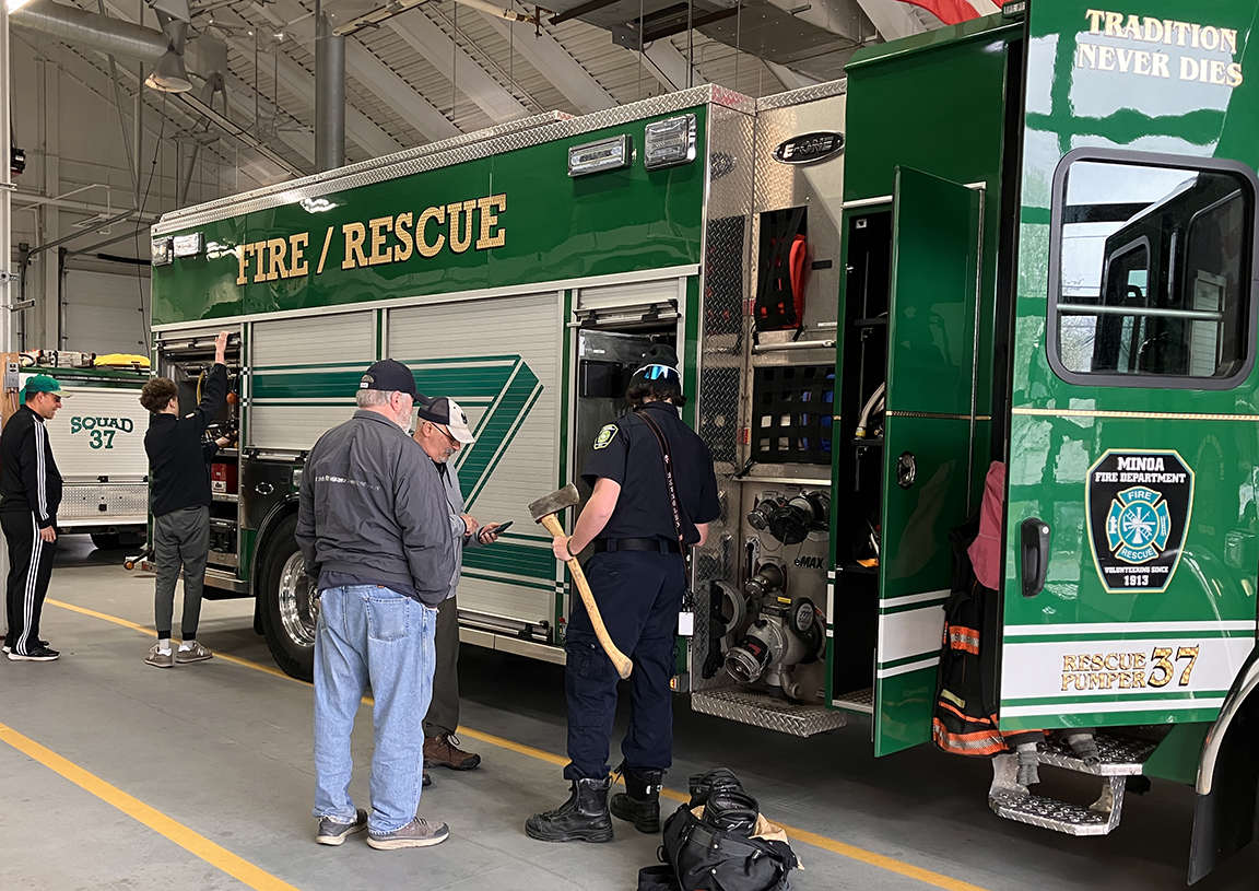 Firefighters showing neighbors the resources they have to work with on a fire truck