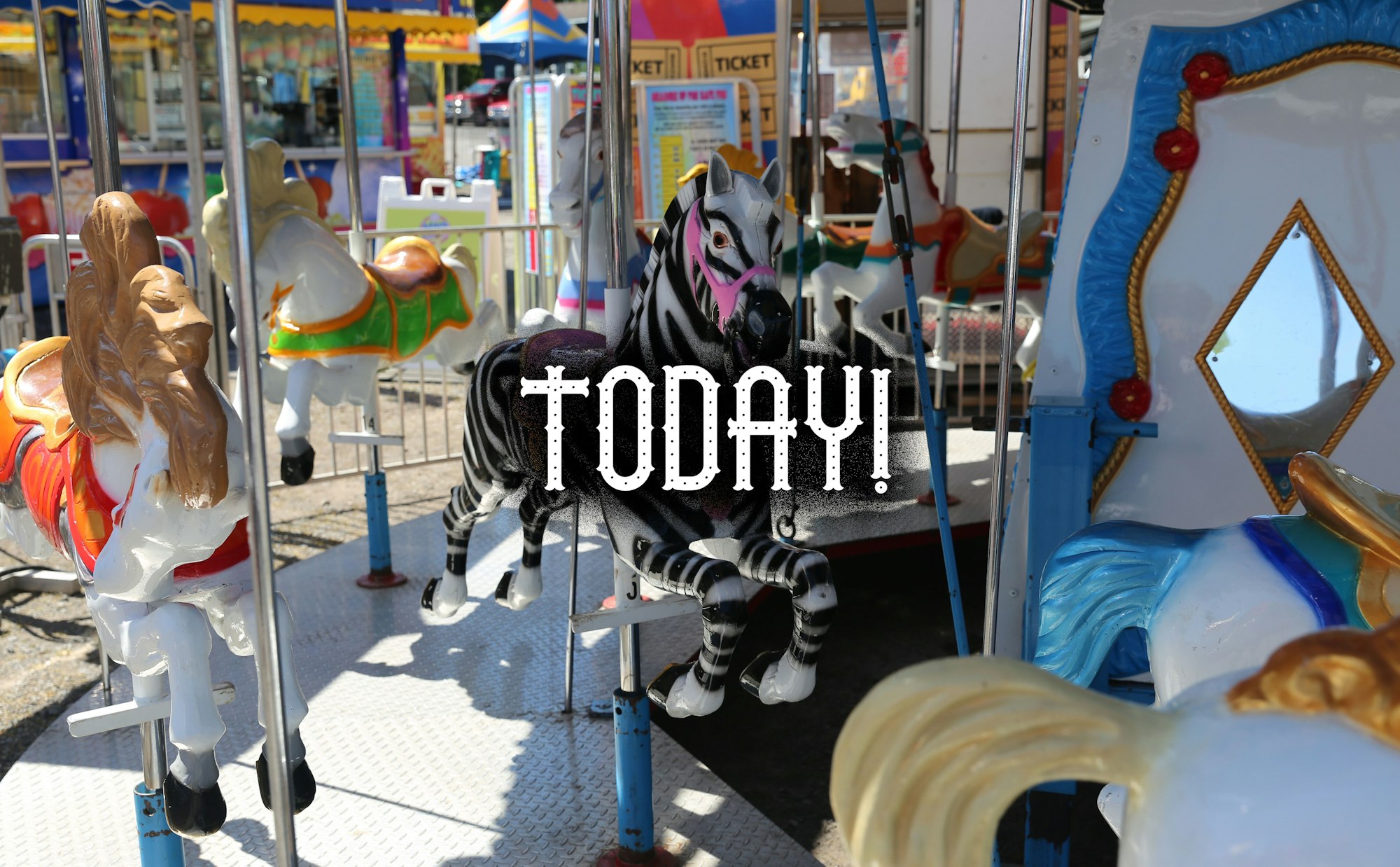 Carousel horses and "TODAY!" text overlay at an amusement park.