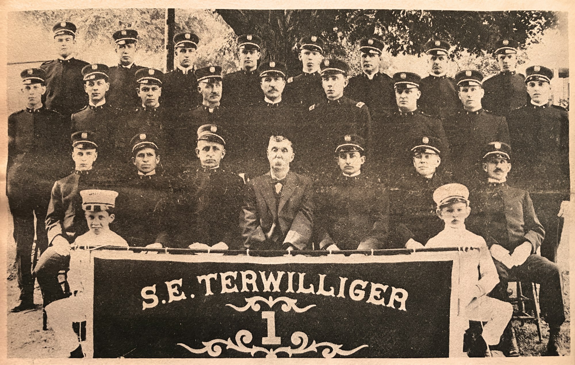 A vintage group photo of uniformed Minoa firemen with a banner reading "S.E. TERWILLIGER 1."