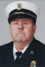 Charlie Mullane wearing a dark uniform and a white cap with a badge, representing a formal or official role.