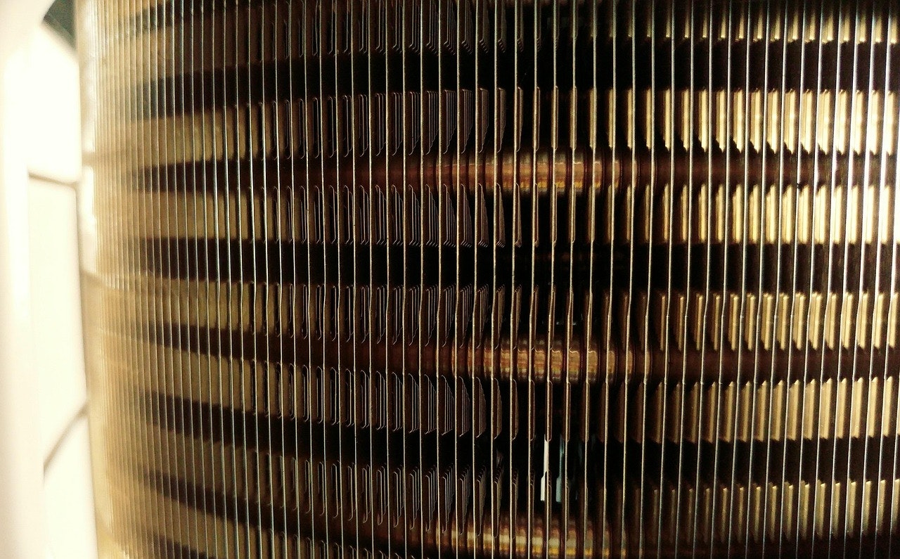 The image shows a close-up of a metallic or textured surface with thin, parallel lines, likely part of a cooling or heating element.