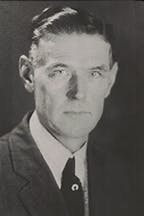 A black and white portrait of Fred McKinley in a suit and tie.