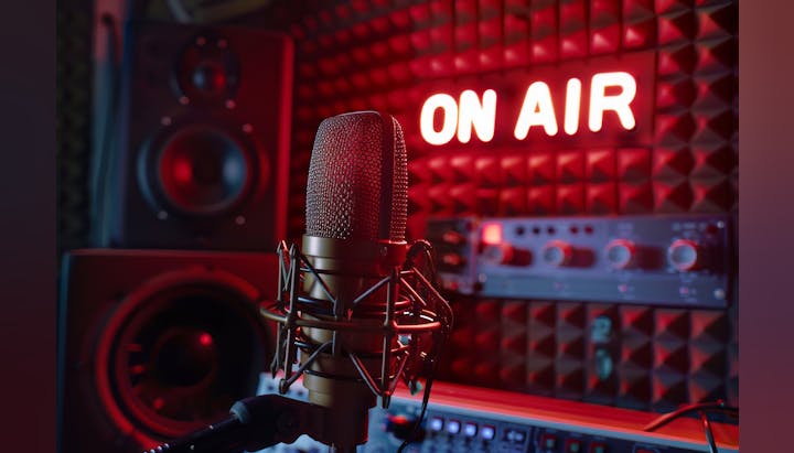Professional studio microphone with "ON AIR" sign in the background, indicating a live broadcast or recording session.