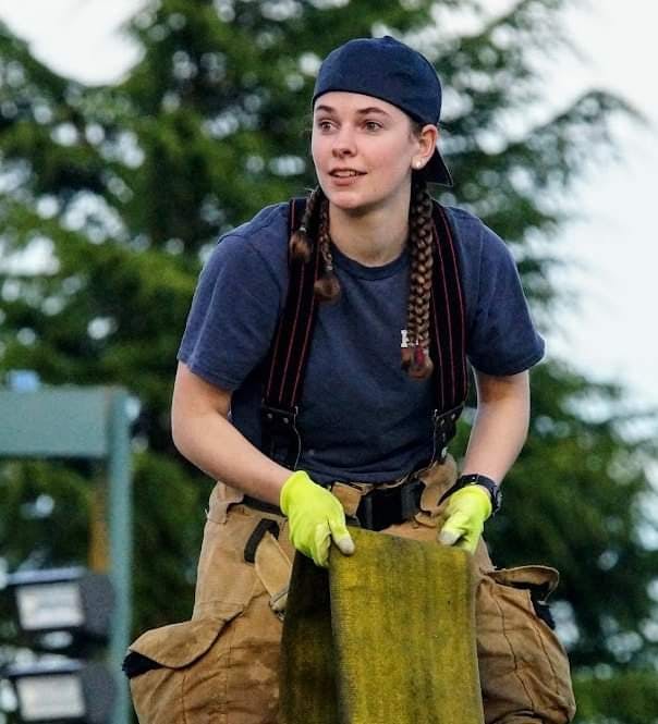 Volunteer Firefighter folding fire hose on an engine