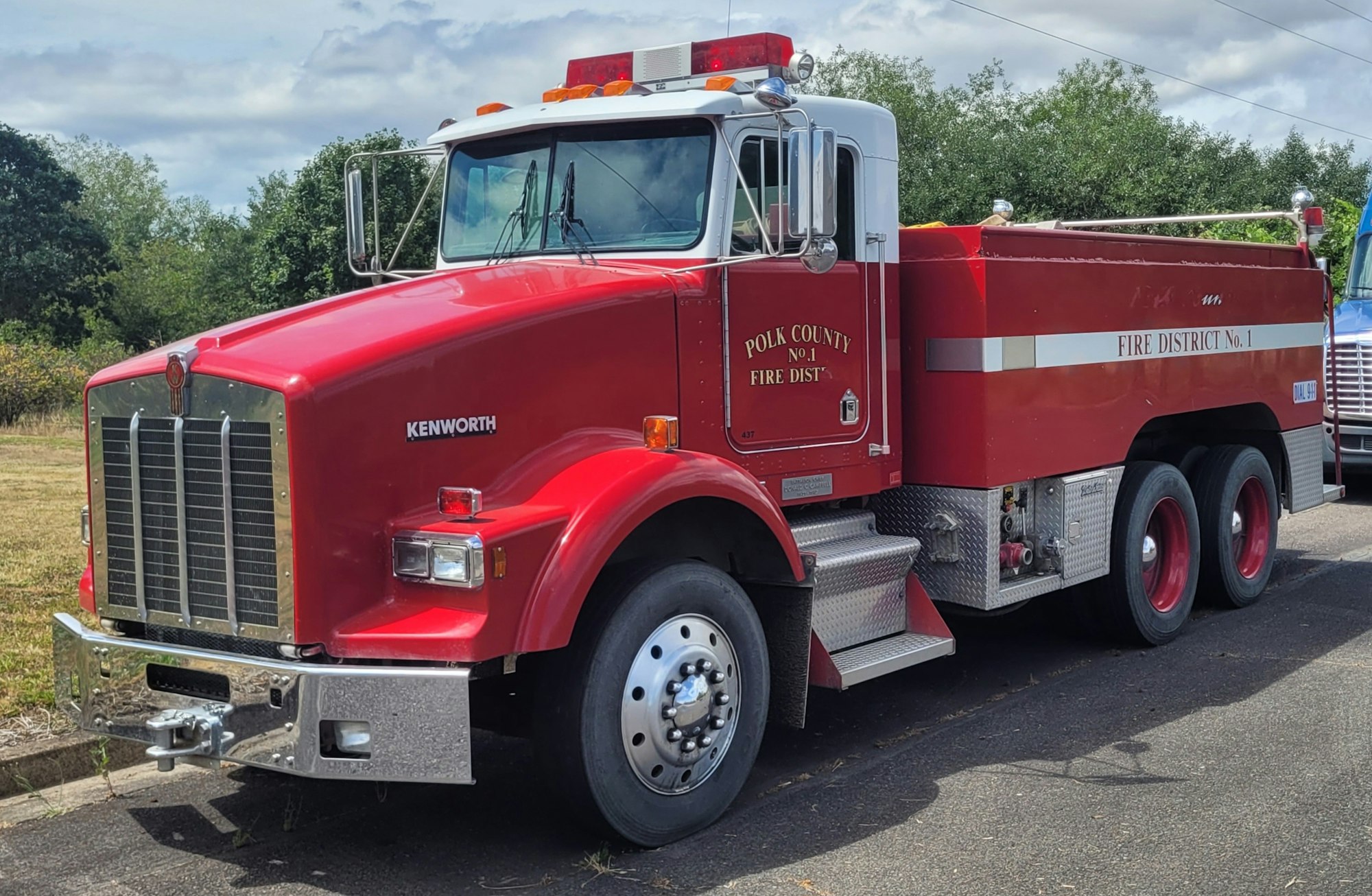Red Kenworth fire truck labeled "Polk County No. 1 Fire Dist.," parked on a road.
