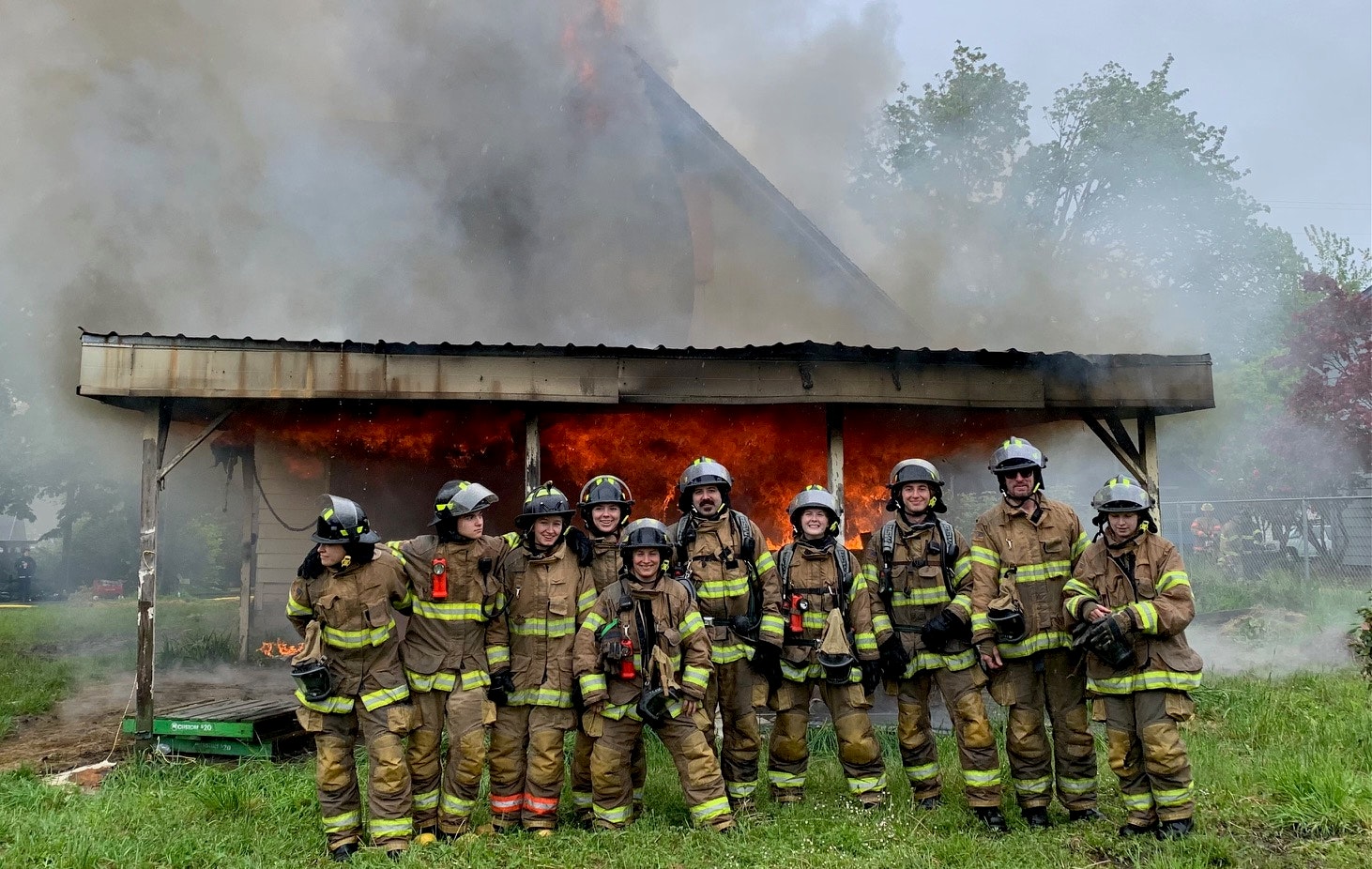 Firefighters in front of a burning house.