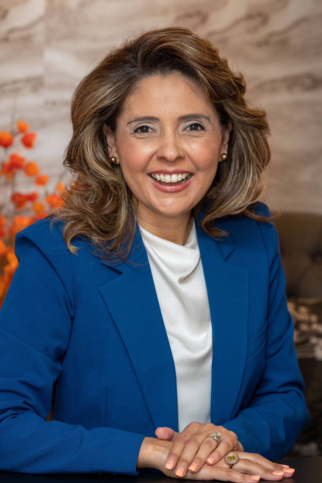 Image description: A photograph of Ida Lopez Chan, smiling, with short brown hair curled, wearing a white blouse and a blue suit.