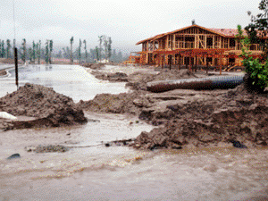 Construction site with erosion of soil due to heavy storm, creating mud.