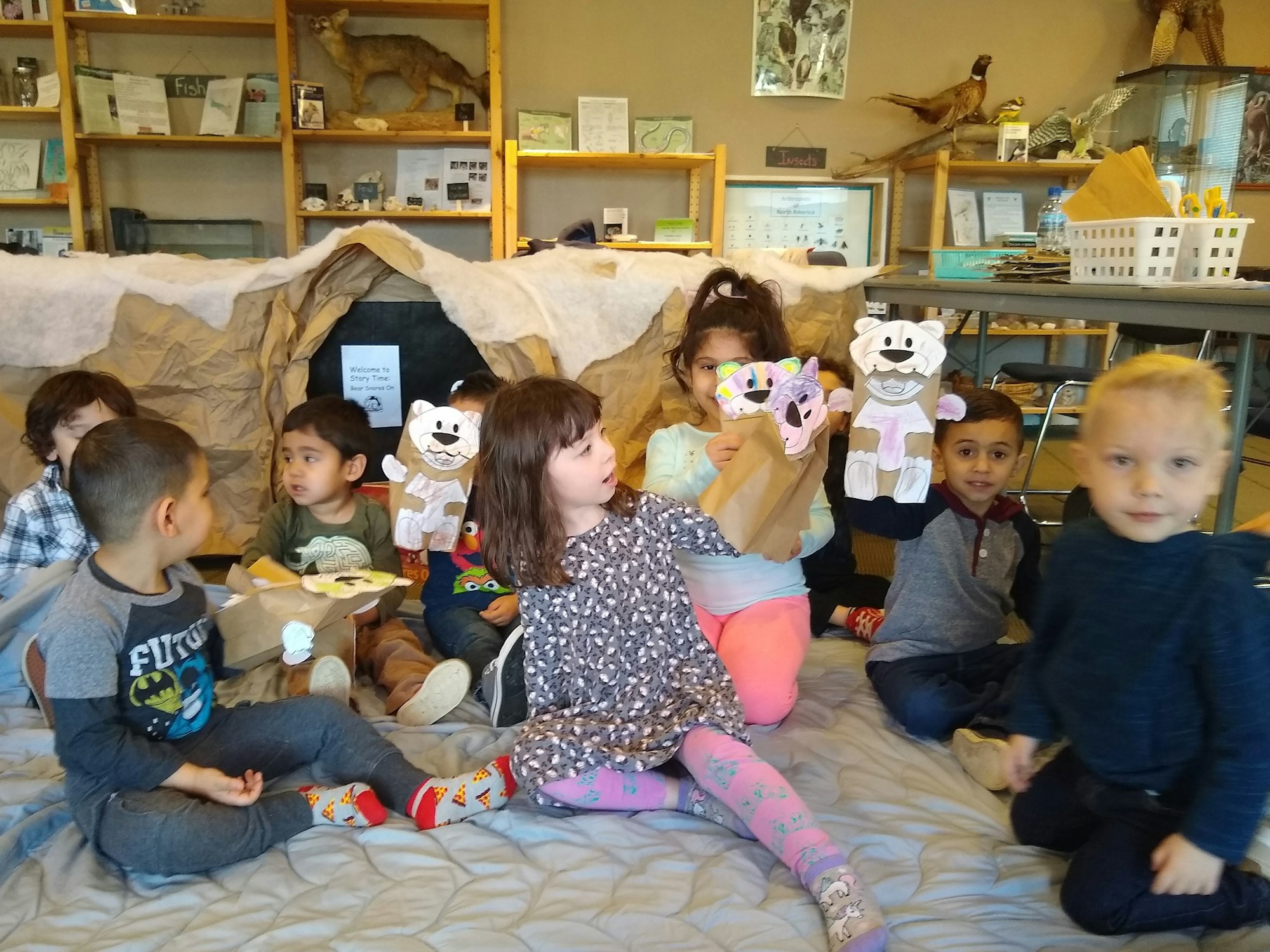 Image of children holding up nature craft they did.