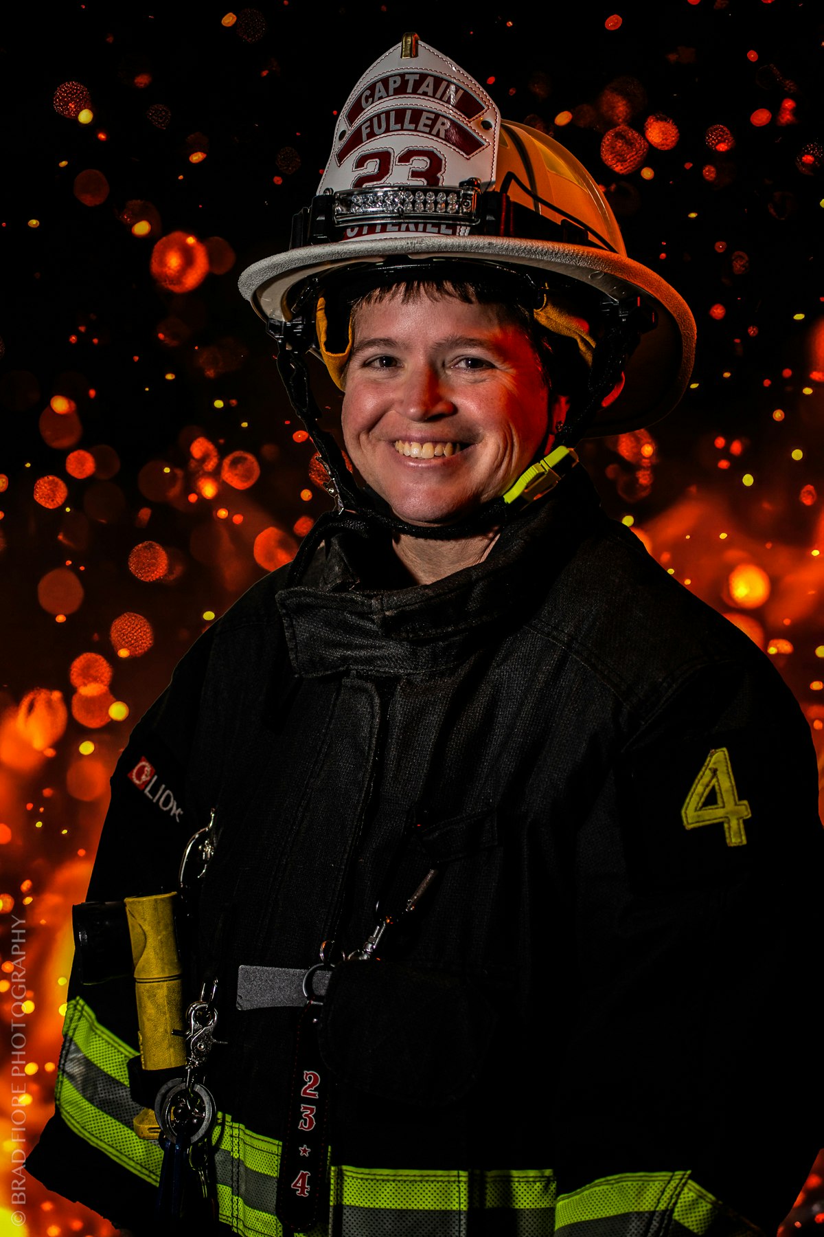 A smiling firefighter in gear with a helmet labeled "Captain Fuller 23," against a fiery bokeh background.
