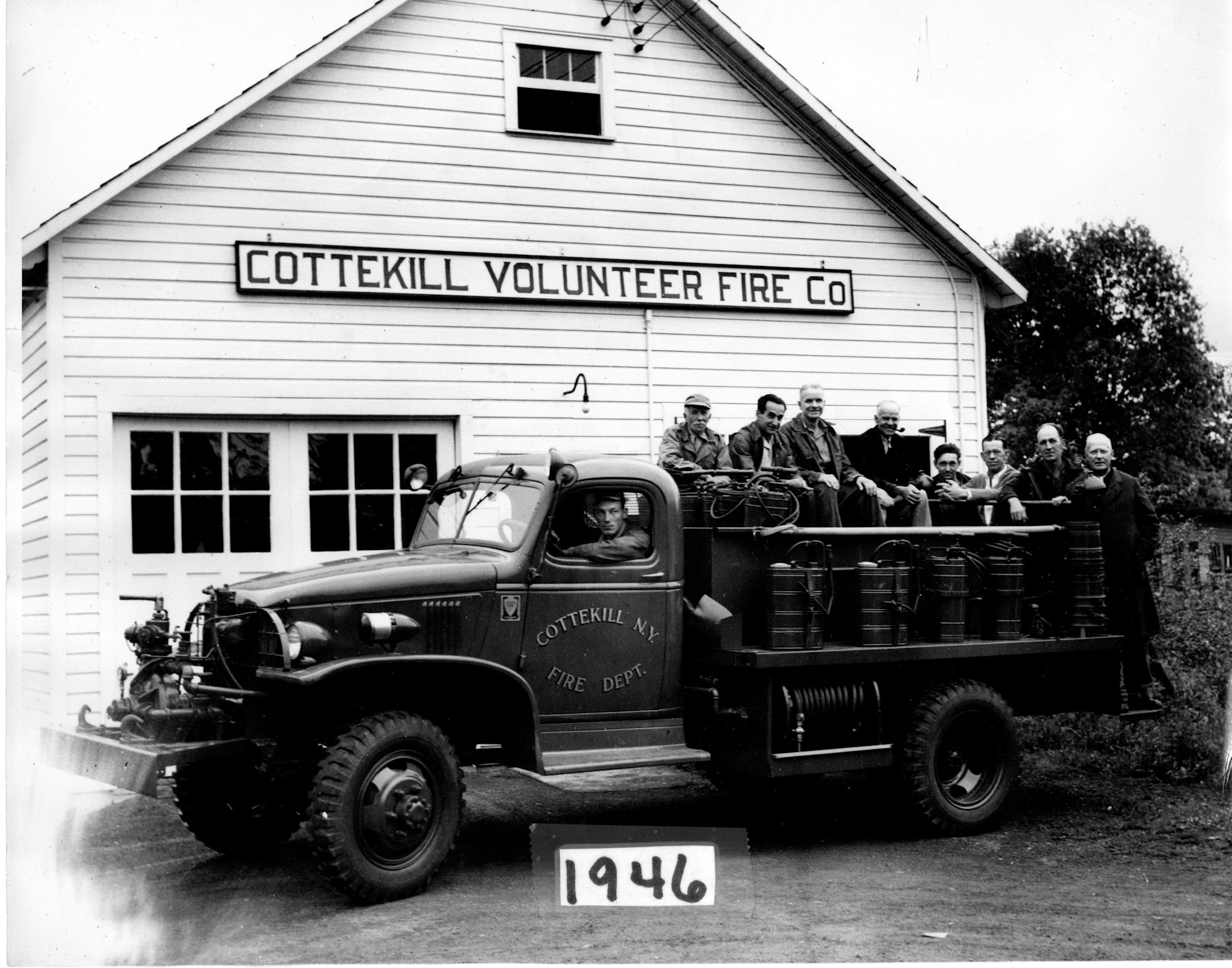 A vintage photo of firefighters with their fire truck outside the Cottekill Volunteer Fire Co. building, dated 1946.