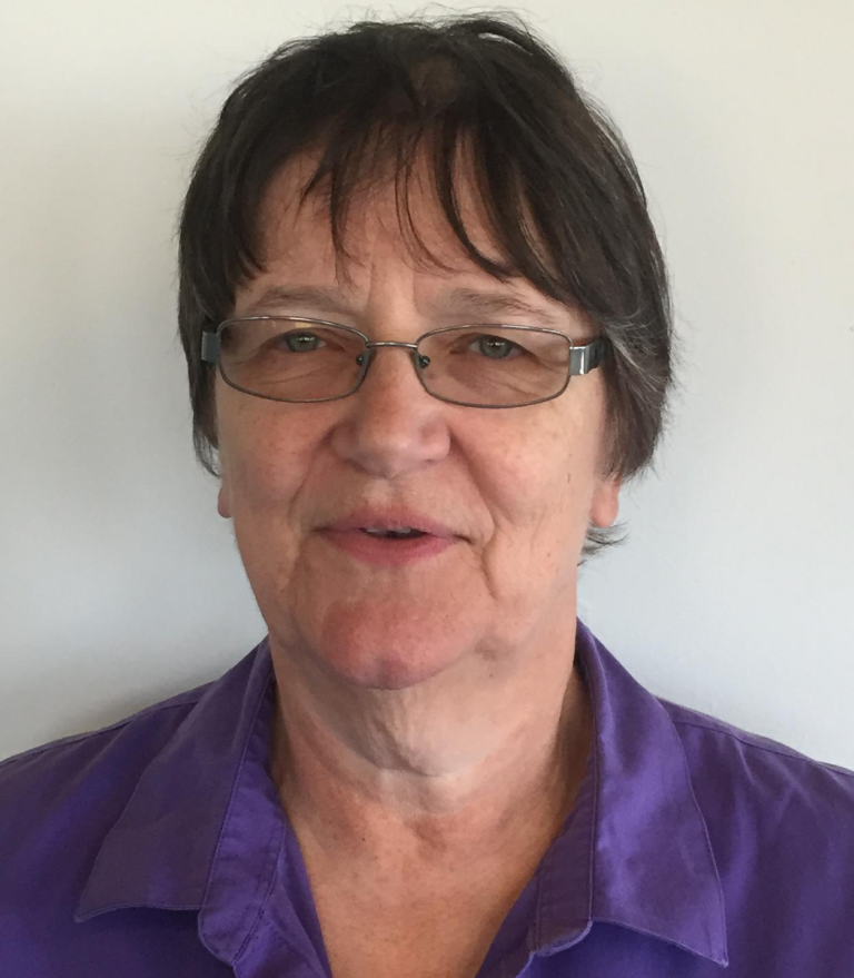 A woman in glasses and a purple shirt.
