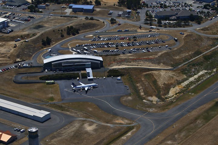 Airport with a United Express jet, parking lot, and leased buildings.