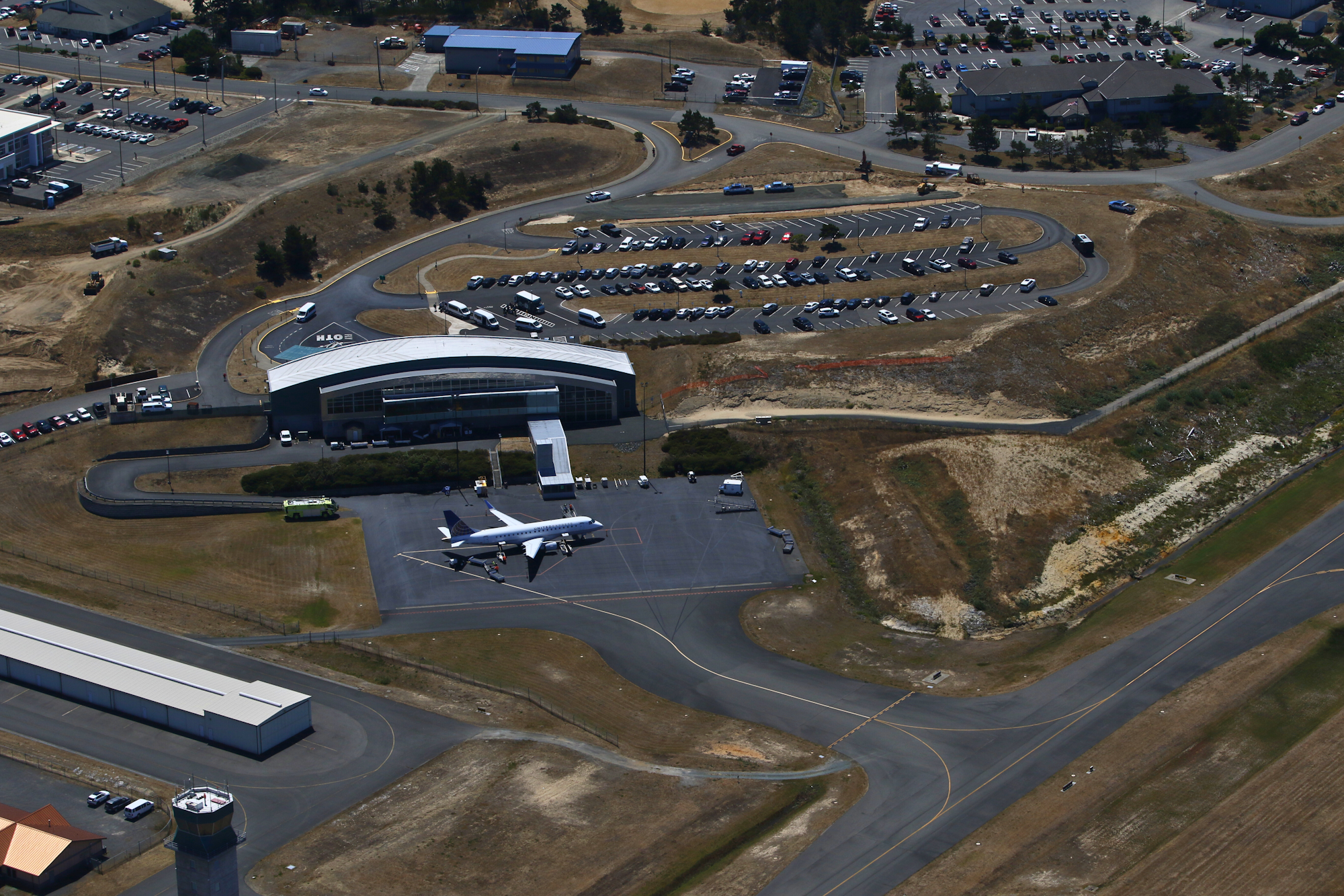 Airport with a United Express jet, parking lot, and leased buildings.