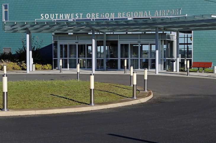Entrance of Southwest Oregon Regional Airport with clear skies above.