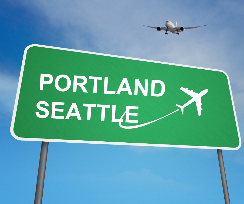 A road sign with "PORTLAND SEATTLE" and an airplane graphic, with a real plane flying overhead against a blue sky.