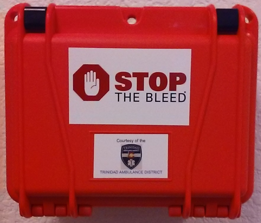 Red "Stop the Bleed" kit, courtesy of Trinidad Ambulance District, suggesting emergency bleeding control supplies inside.