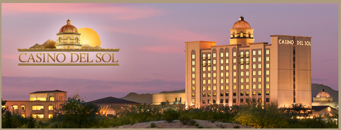 Casino Del Sol building with logo at sunset.
