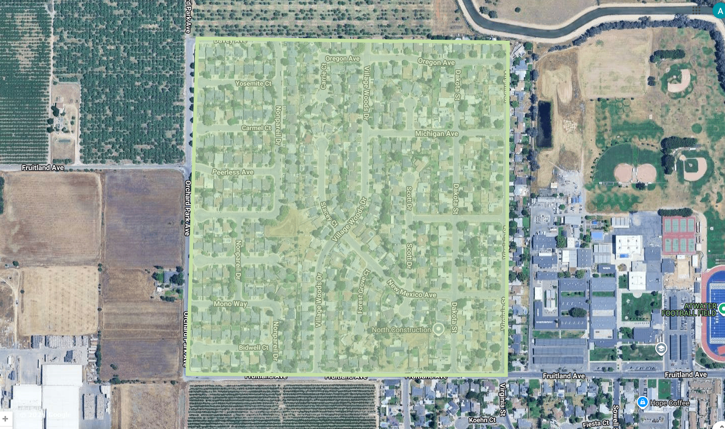 The image shows a map section with residential streets, agricultural land, and nearby sports fields in a suburban area.