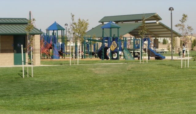Daytime view of park playground and shade structure.